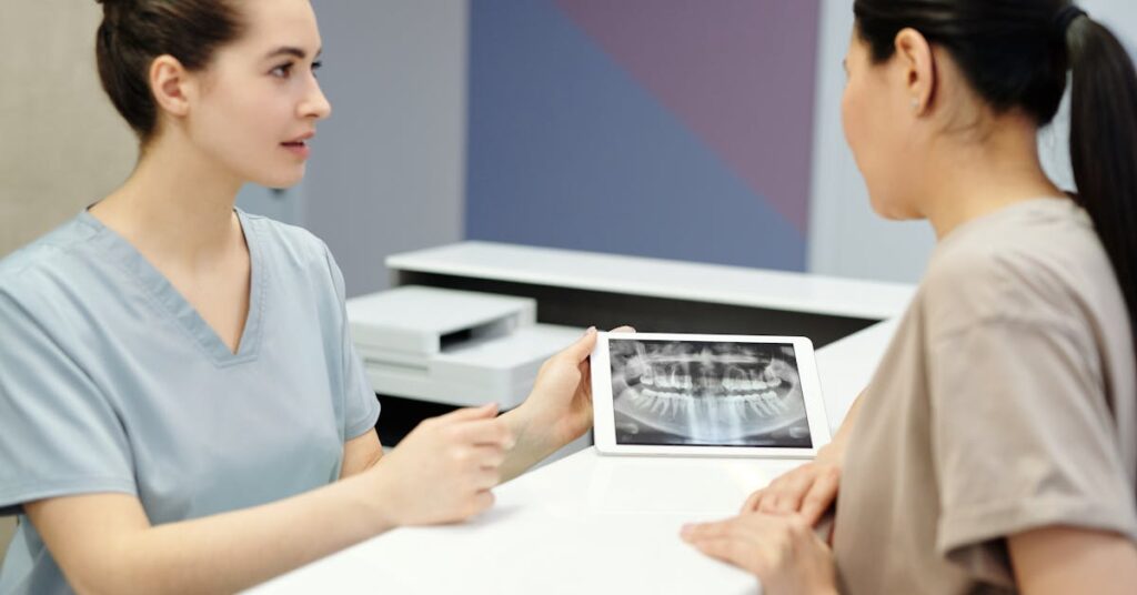 Dentist explaining a dental implant timeline using an X-ray to a patient in Archway