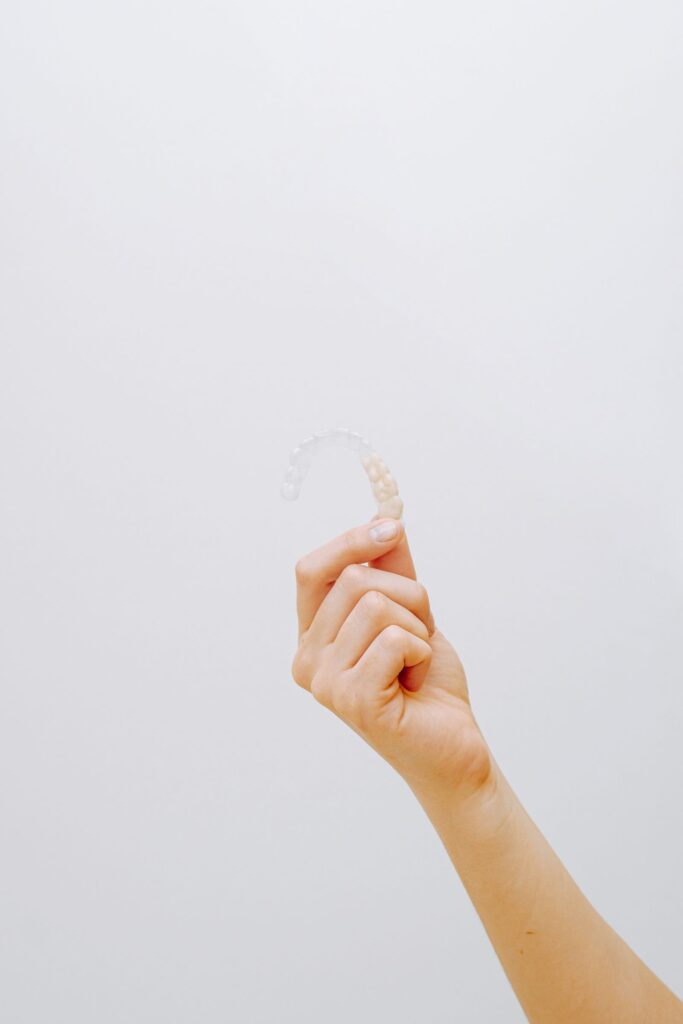 Person holding a clear Invisalign aligner, illustrating Invisalign cost in Archway at Blue Light Dental