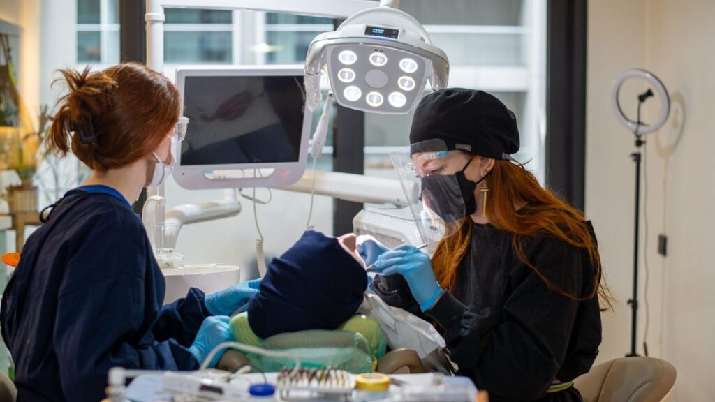 Dentist carrying out root canal treatment on a patient in the dental chair, illustrating root canal cost in North London