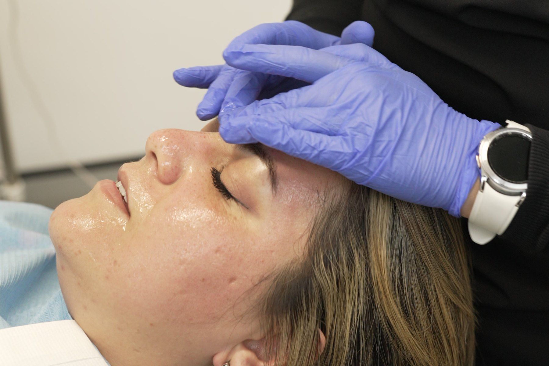 Clinician using gentle massage technique after a facial injectable treatment at Blue Light Dental in Archway